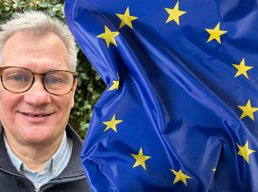 Portræt af Niels Sørensen på en baggrund af det blå EU-flag med gule stjerner 